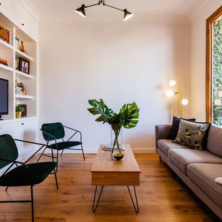 Ejemplo de sala de estar cerrada, nórdica, con paredes beige, suelo de madera en tonos medios, televisor independiente y suelo marrón