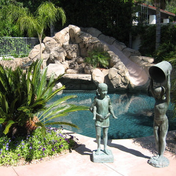 Pool and patio with stone / rock walls and deck