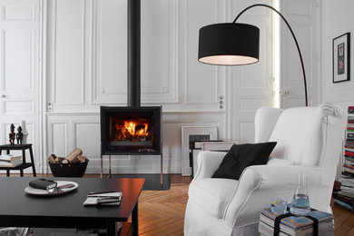 Aménagement d'un grand salon classique fermé avec un poêle à bois, une salle de réception, un mur blanc, un sol en bois brun et aucun téléviseur.
