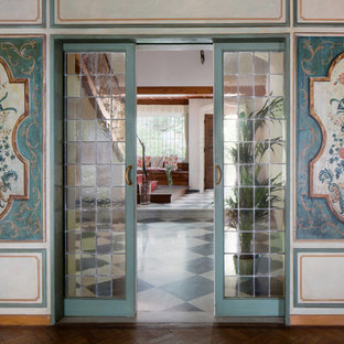 Inredning av en klassisk mellanstor hall, med flerfärgade väggar, mellanmörkt trägolv och brunt golv