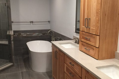 Mid-sized trendy master gray tile and porcelain tile porcelain tile bathroom photo in Tampa with shaker cabinets, light wood cabinets, a two-piece toilet, gray walls, an undermount sink and quartzite countertops