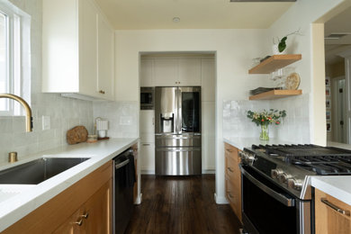 Example of a small beach style galley medium tone wood floor and brown floor eat-in kitchen design in San Diego with an undermount sink, shaker cabinets, light wood cabinets, wood countertops, white backsplash, ceramic backsplash, stainless steel appliances, a peninsula and white countertops