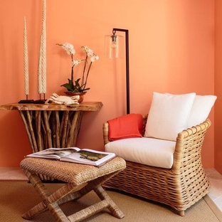 This is an example of a mid-sized mediterranean guest bedroom in Santa Barbara with orange walls and travertine floors.