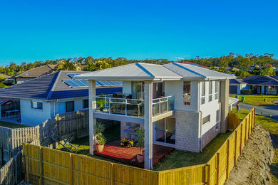 Mid-sized modern balcony in Gold Coast - Tweed with a roof extension and mixed railing.