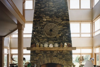 Foto de salón abierto de estilo de casa de campo con suelo de madera en tonos medios y marco de chimenea de piedra