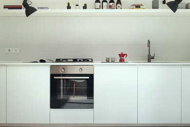 Ispirazione per una piccola cucina contemporanea con lavello a vasca singola, ante a filo, ante bianche, top in legno, paraspruzzi grigio, paraspruzzi con piastrelle in ceramica, elettrodomestici in acciaio inossidabile, pavimento in cemento, nessuna isola, pavimento grigio e top bianco