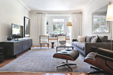 Example of a mid-sized transitional enclosed medium tone wood floor living room design in San Francisco with white walls and a tv stand