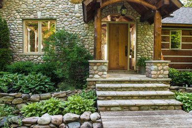 Photo of a mid-sized eclectic two-storey exterior in Toronto with stone veneer.
