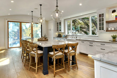 Example of a huge classic u-shaped light wood floor and beige floor open concept kitchen design in San Francisco with a farmhouse sink, beaded inset cabinets, white cabinets, quartzite countertops, white backsplash, ceramic backsplash, stainless steel appliances, an island and gray countertops