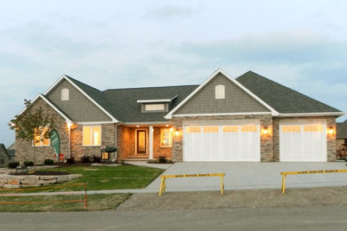 Inspiration for a large transitional gray one-story stone exterior home remodel in Other with a hip roof