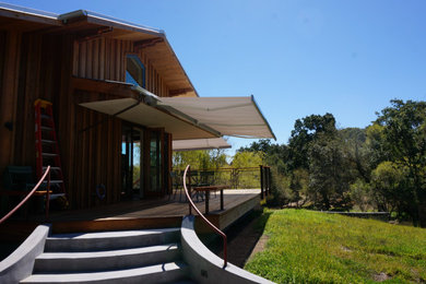 Mid-sized country two-story wood and board and batten exterior home photo in San Francisco with a metal roof and a gray roof