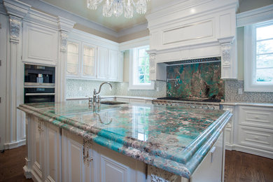 Large elegant u-shaped medium tone wood floor eat-in kitchen photo in DC Metro with an undermount sink, glass-front cabinets, light wood cabinets, marble countertops, white backsplash, porcelain backsplash, stainless steel appliances and two islands