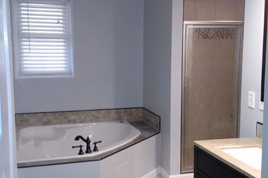 Inspiration for a mid-sized transitional master porcelain tile and beige floor bathroom remodel in Other with shaker cabinets, black cabinets, a two-piece toilet, gray walls, an undermount sink, laminate countertops, a hinged shower door and beige countertops