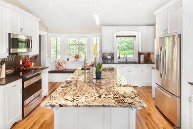 Example of a mid-sized transitional u-shaped light wood floor eat-in kitchen design in Other with an undermount sink, raised-panel cabinets, white cabinets, quartzite countertops, metallic backsplash, mosaic tile backsplash, stainless steel appliances and an island