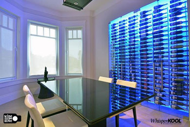 Mid-sized modern wine cellar with light hardwood floors, display racks and white floor.