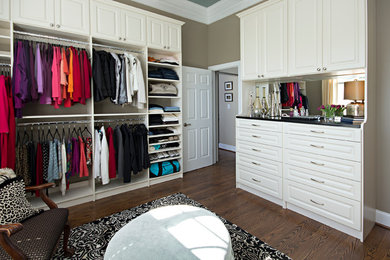 Inspiration for a large timeless gender-neutral dark wood floor and brown floor walk-in closet remodel in Raleigh with raised-panel cabinets and white cabinets