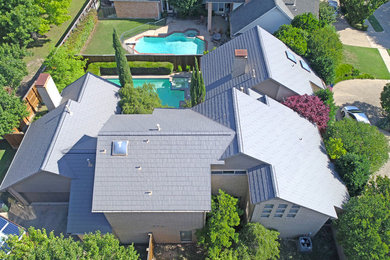 Inspiration for a large modern beige two-story concrete exterior home remodel in Dallas with a mixed material roof