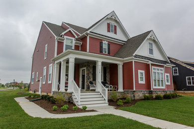 Inspiration for a mid-sized timeless red two-story mixed siding gable roof remodel in Philadelphia