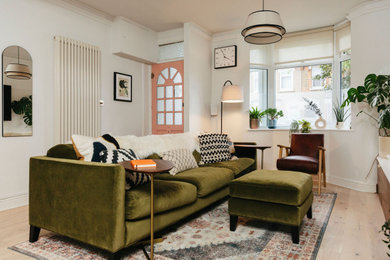 Design ideas for a medium sized midcentury open plan living room in London with white walls, light hardwood flooring, no fireplace, a wall mounted tv, beige floors and feature lighting.