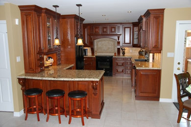 Inspiration for a mid-sized timeless u-shaped ceramic tile and beige floor kitchen remodel in Toronto with an undermount sink, black appliances, a peninsula, raised-panel cabinets, medium tone wood cabinets, granite countertops, beige backsplash and multicolored countertops