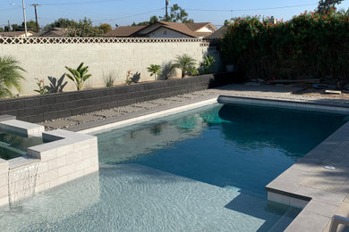 Mid-sized trendy backyard concrete paver and rectangular pool photo in Los Angeles