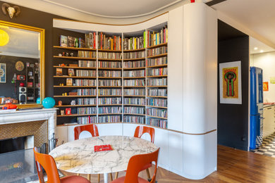 Idée de décoration pour une salle à manger bohème avec un mur noir, un sol en bois brun et un sol marron.
