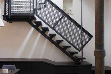 This is an example of a mid-sized contemporary wood straight staircase in New York with metal risers.