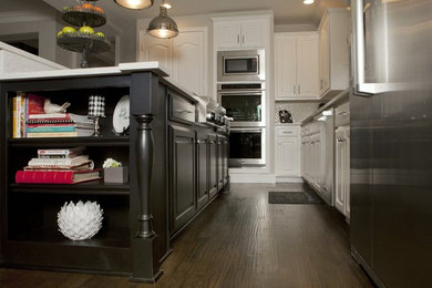 Inspiration for a large contemporary l-shaped medium tone wood floor eat-in kitchen remodel in Dallas with an undermount sink, raised-panel cabinets, black cabinets, solid surface countertops, stainless steel appliances and an island