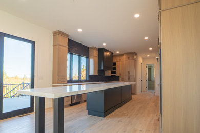 Example of a large transitional u-shaped light wood floor and beige floor eat-in kitchen design in Boston with an undermount sink, shaker cabinets, light wood cabinets, quartz countertops, gray backsplash, ceramic backsplash, stainless steel appliances, an island and white countertops