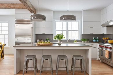 Inspiration for a mid-sized country l-shaped eat-in kitchen in Dallas with a double-bowl sink, flat-panel cabinets, yellow cabinets, quartz benchtops, grey splashback, marble splashback, stainless steel appliances, light hardwood floors, with island, beige floor and grey benchtop.