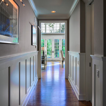 Entry hall with recessed panel wainscot walls enjoys view to backyard