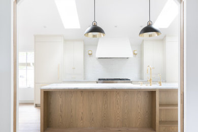 Example of a classic light wood floor and vaulted ceiling hallway design in Vancouver with white walls