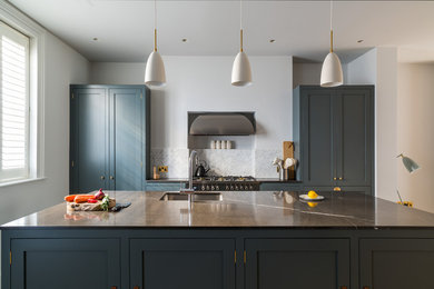 Mid-sized traditional eat-in kitchen in London with a single-bowl sink, shaker cabinets, blue cabinets, marble benchtops, white splashback, marble splashback, stainless steel appliances, dark hardwood floors and with island.