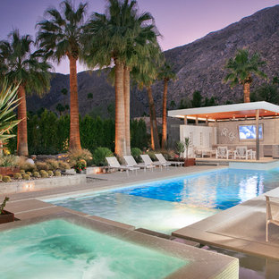 Großer Mid-Century Infinity-Pool hinter dem Haus in rechteckiger Form mit Poolhaus und Betonplatten in San Diego