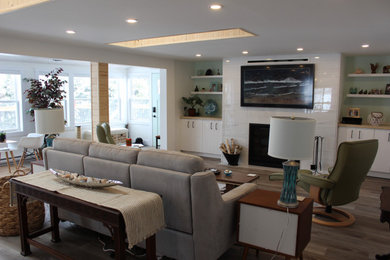 Example of a large cottage open concept vinyl floor and gray floor living room design in Other with white walls, a standard fireplace, a tile fireplace and a wall-mounted tv