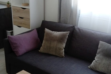 Aménagement d'un petit salon moderne ouvert avec un téléviseur indépendant, un mur vert, sol en stratifié et un sol beige.
