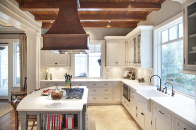 Inspiration for a mid-sized timeless u-shaped limestone floor eat-in kitchen remodel in Charleston with shaker cabinets, a farmhouse sink, white cabinets, marble countertops, beige backsplash, matchstick tile backsplash, stainless steel appliances and an island