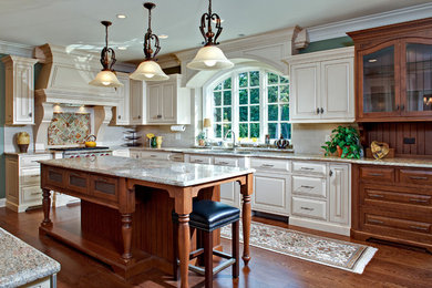 Inspiration for a large timeless l-shaped medium tone wood floor eat-in kitchen remodel in Chicago with a double-bowl sink, recessed-panel cabinets, white cabinets, granite countertops, beige backsplash, subway tile backsplash and stainless steel appliances