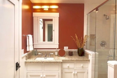Inspiration for a small timeless 3/4 white tile and ceramic tile limestone floor, beige floor and single-sink corner shower remodel in San Diego with furniture-like cabinets, white cabinets, orange walls, an undermount sink, granite countertops, a hinged shower door, beige countertops and a built-in vanity