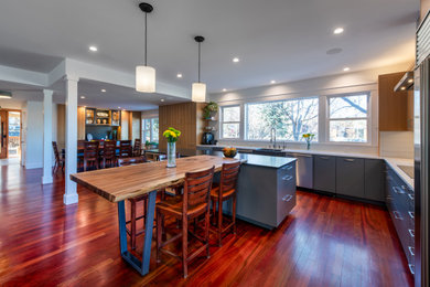 Inspiration for a large contemporary l-shaped open concept kitchen remodel in Denver with a farmhouse sink, flat-panel cabinets, stainless steel appliances and an island