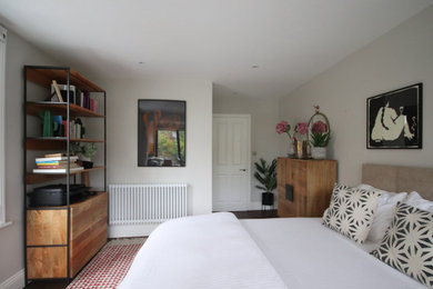 ケンブリッジシャーにある広いコンテンポラリースタイルのおしゃれな客用寝室 (白い壁、濃色無垢フローリング、茶色い床)