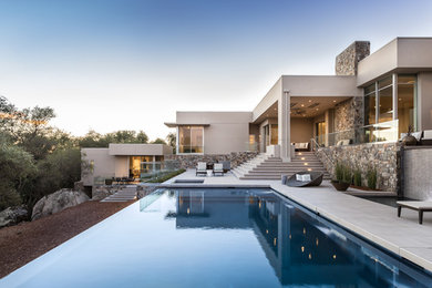 Photo of a large contemporary backyard rectangular infinity pool in Sacramento with a hot tub and concrete slab.