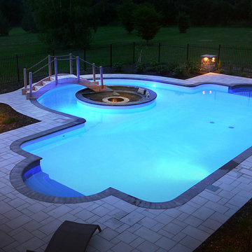 Pool with a firepit by Exact Landscapes