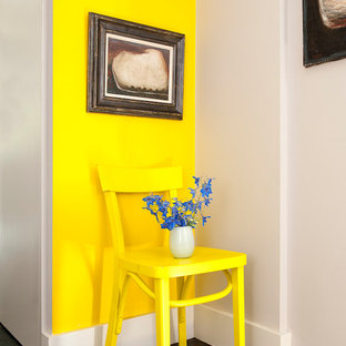 Shabby chic-inspirerad inredning av en mellanstor hall, med gula väggar och målat trägolv