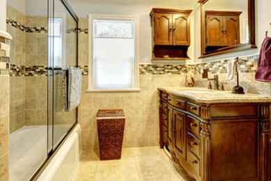 Inspiration for a mid-sized timeless 3/4 beige tile and ceramic tile ceramic tile and beige floor bathroom remodel in DC Metro with raised-panel cabinets, dark wood cabinets, a two-piece toilet, beige walls, an undermount sink and granite countertops