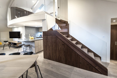 Photo of a large contemporary wood staircase in London with wood risers.