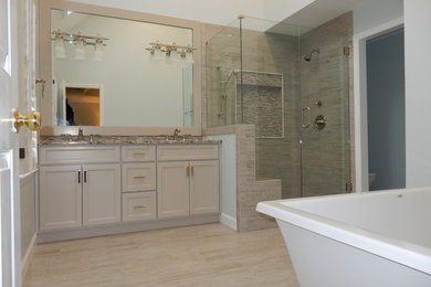 Large contemporary master bathroom in Atlanta with shaker cabinets, a freestanding tub, a corner shower and beige walls.