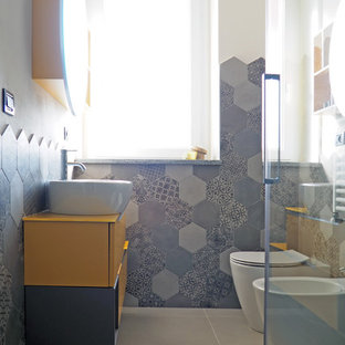 Idee per un piccolo bagno di servizio moderno con ante lisce, ante gialle, bidè, piastrelle grigie, piastrelle in gres porcellanato, pareti bianche, pavimento in gres porcellanato, lavabo a bacinella, pavimento grigio e top giallo