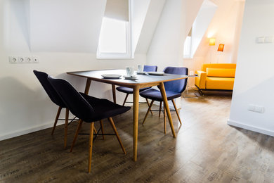Nordische Wohnküche mit weißer Wandfarbe und braunem Holzboden in Nürnberg