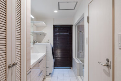 東京23区にある小さな地中海スタイルのおしゃれなトイレ・洗面所 (白いキャビネット、白い壁、磁器タイルの床、白い床、造り付け洗面台、クロスの天井、壁紙、白い天井) の写真